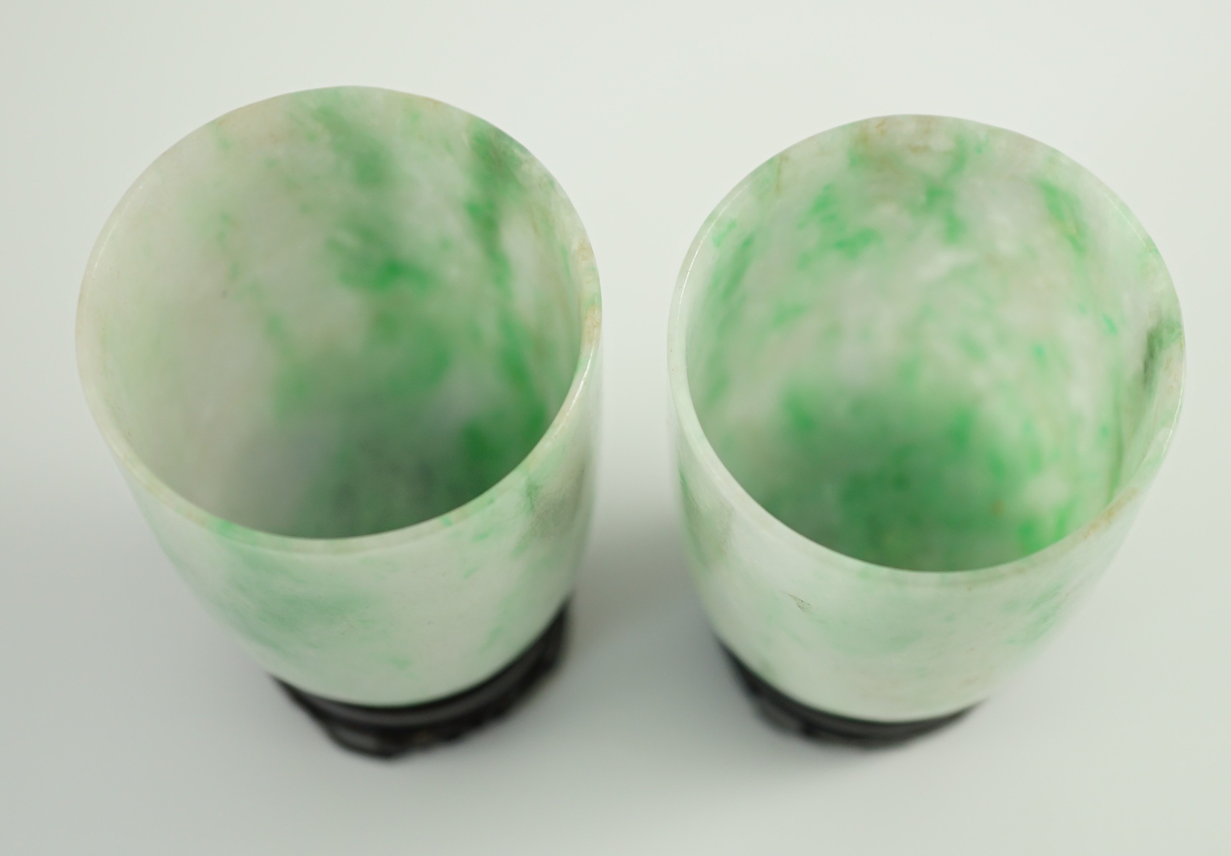 A pair of Chinese jadeite cups, 6.2cm high, wood stands, fitted box